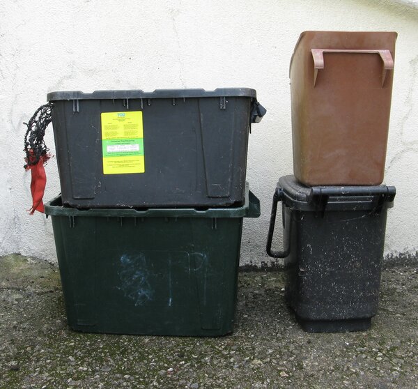 Photo (c) J. G Betts On left two black recycling boes one on top o another. On left brown food caddy on top of black one.